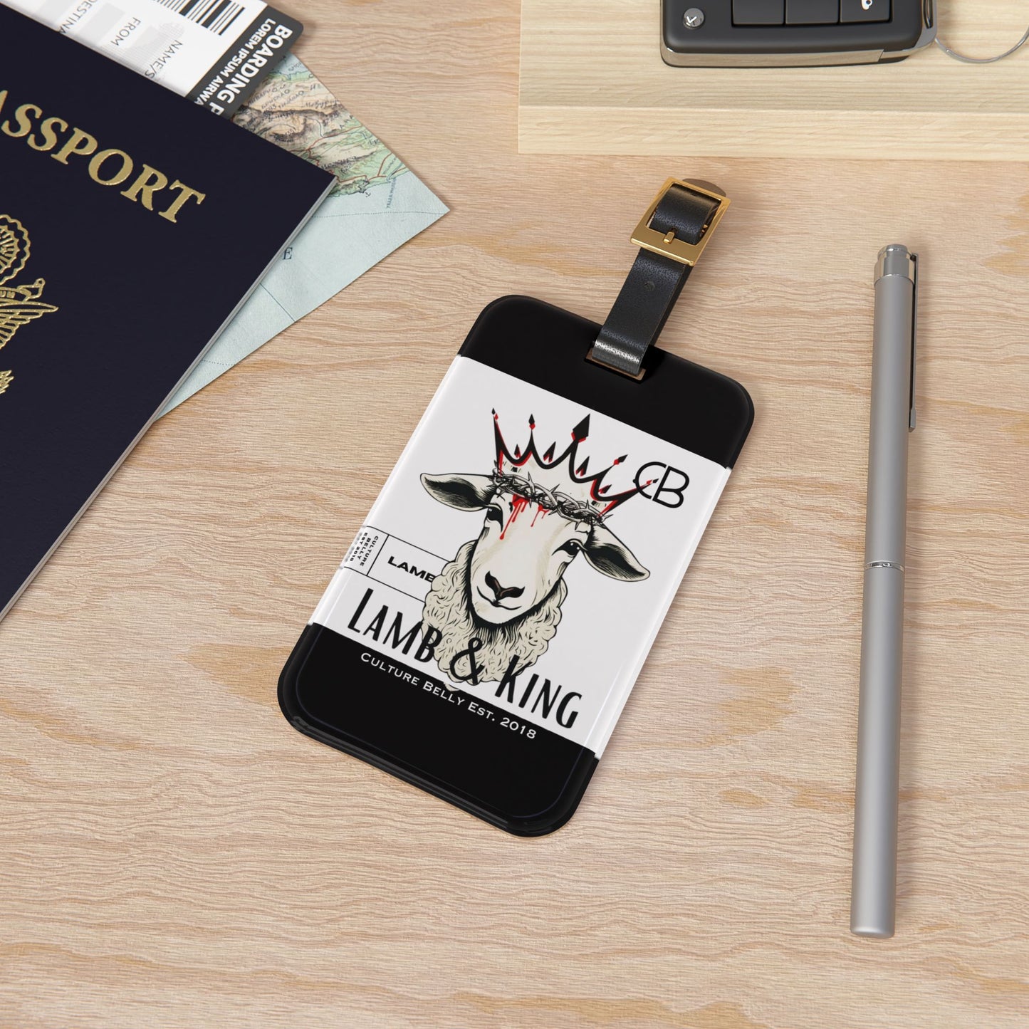 Black and white luggage tag featuring the Lamb & King faithwear design, displaying the iconic crowned lamb graphic with Culture Belly branding, symbolizing spiritual strength and faith on the go.